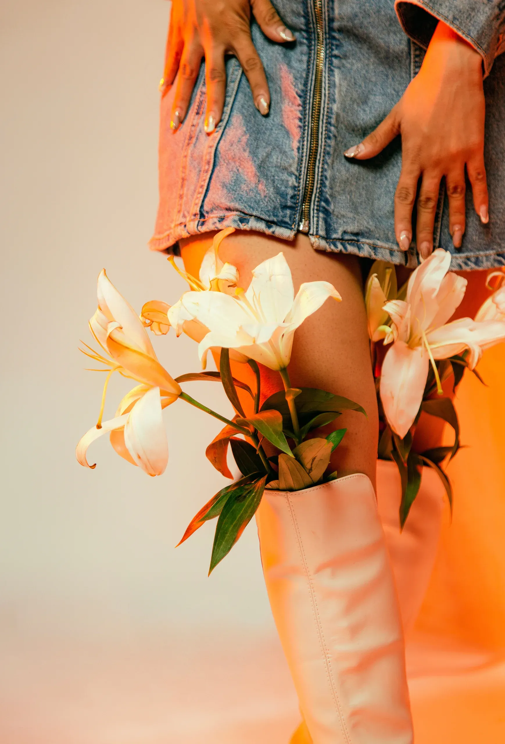 Editorial fashion styling by Roma Agarwal: lilies, denim and leather boots